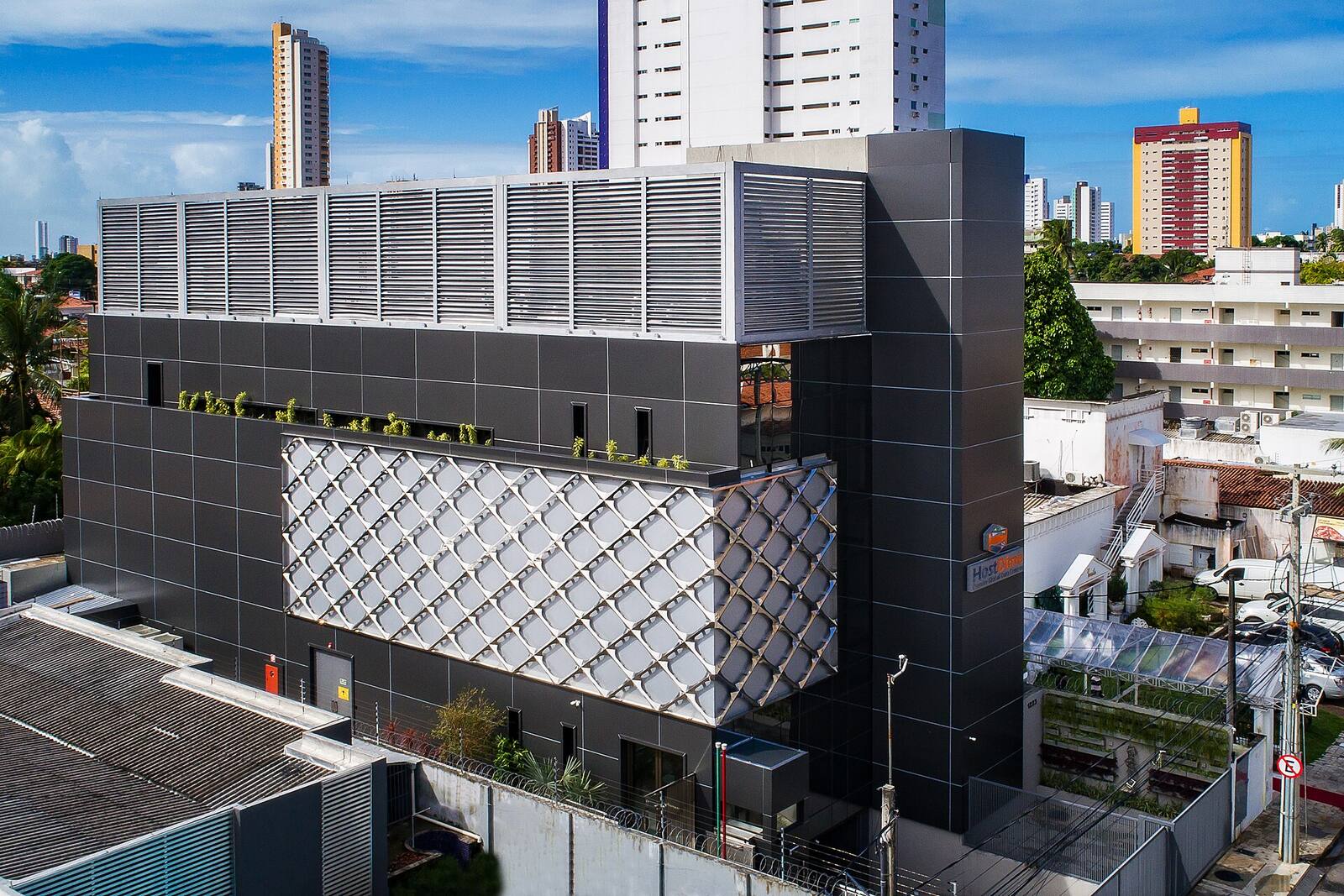 Exterior of a HostDime data center building in João Pessoa, Paraíba, Brazil, standing between apartment towers.